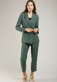 Ensemble de blazer et pantalon à motifs verts et bleus, avec un design en losange, coupe ajustée et tissu lisse. Agrémenté d'un col à revers.