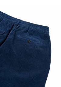 Pantaloni di velluto a coste color blu navy con texture a coste, vita elasticizzata e una tasca posteriore con chiusura a bottone per un dettaglio in più.