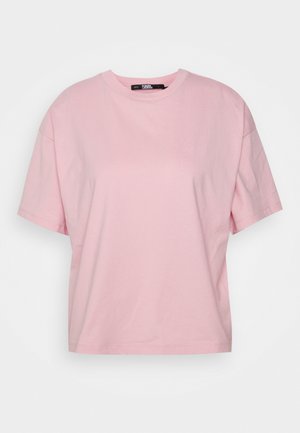 Jasnoróżowy T-shirt z krótkim rękawem i okrągłym dekoltem, o luźnym kroju, przedstawiony na jednolitym białym tle.