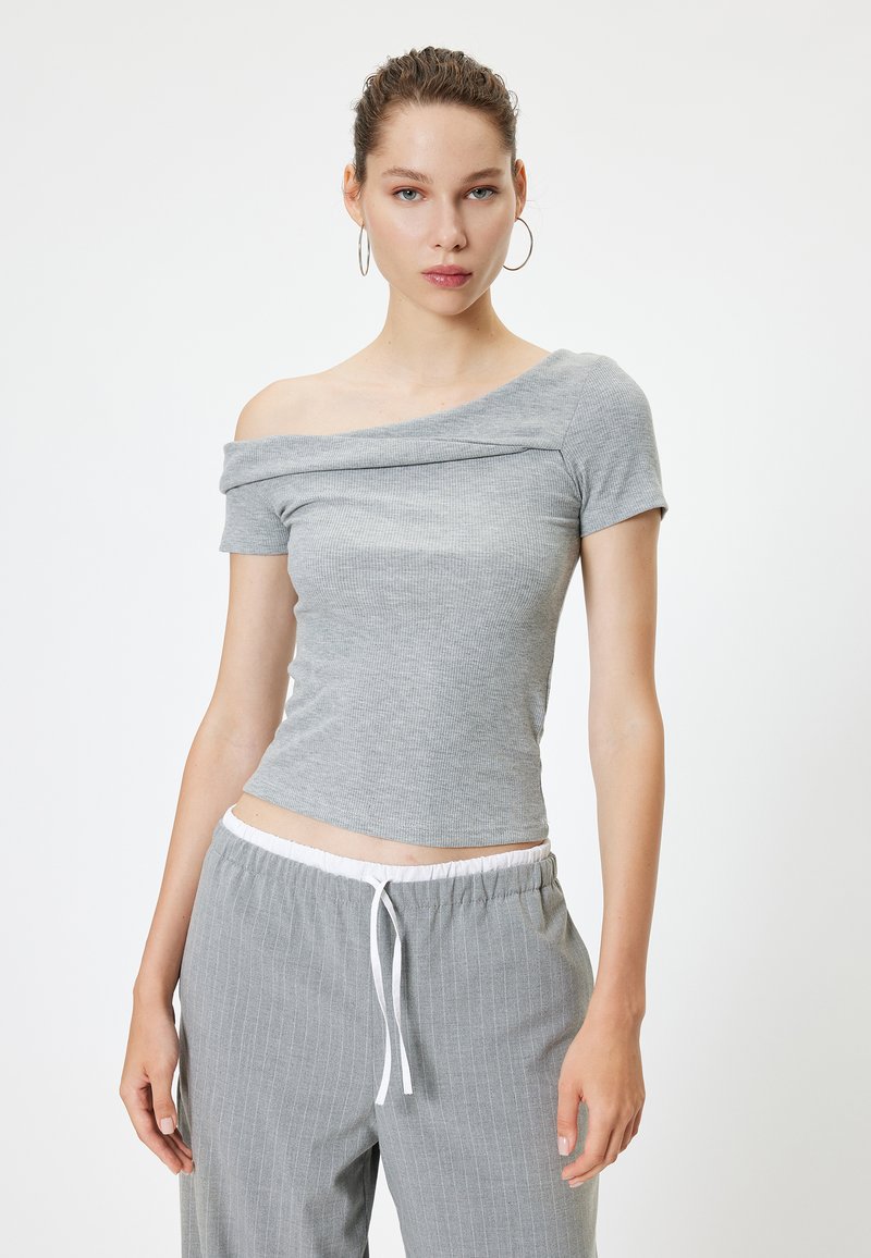 Harmaa ribatty off-the-shoulder-toppi lyhyillä hihoilla ja vartalonmyötäisellä siluetilla, yhdistettynä vaaleanharmaisiin raidallisiin housuihin, joissa on joustava vyötärö.