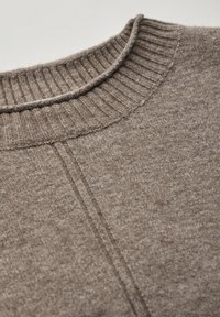 Brauner Strickpullover mit geripptem Kragen. Der glatte Stoff des Körpers weist subtile Variationen auf und hat ein verstärktes Nähdetail an der Naht.