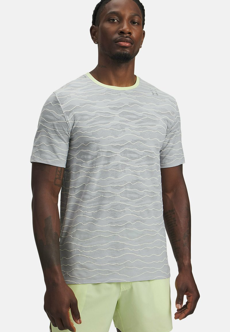 Vaaleanharmaa lyhythihainen t-paita, jossa aaltoileva tekstuurikuosi ja kontrastinen keltainen pääntie. Valmistettu hengittävästä materiaalista.