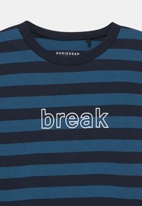 T-shirt rayé bleu marine et teal en coton, avec le mot "break" brodé en blanc sur le devant. Col rond.