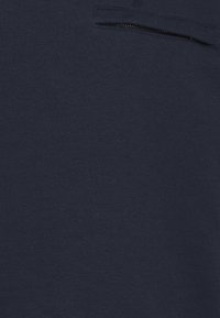 Dunkelblaues Sweatshirt aus weichem Baumwollmaterial, mit einer horizontalen Reißverschlusstasche auf der Brust und einer glatten, gleichmäßigen Textur.