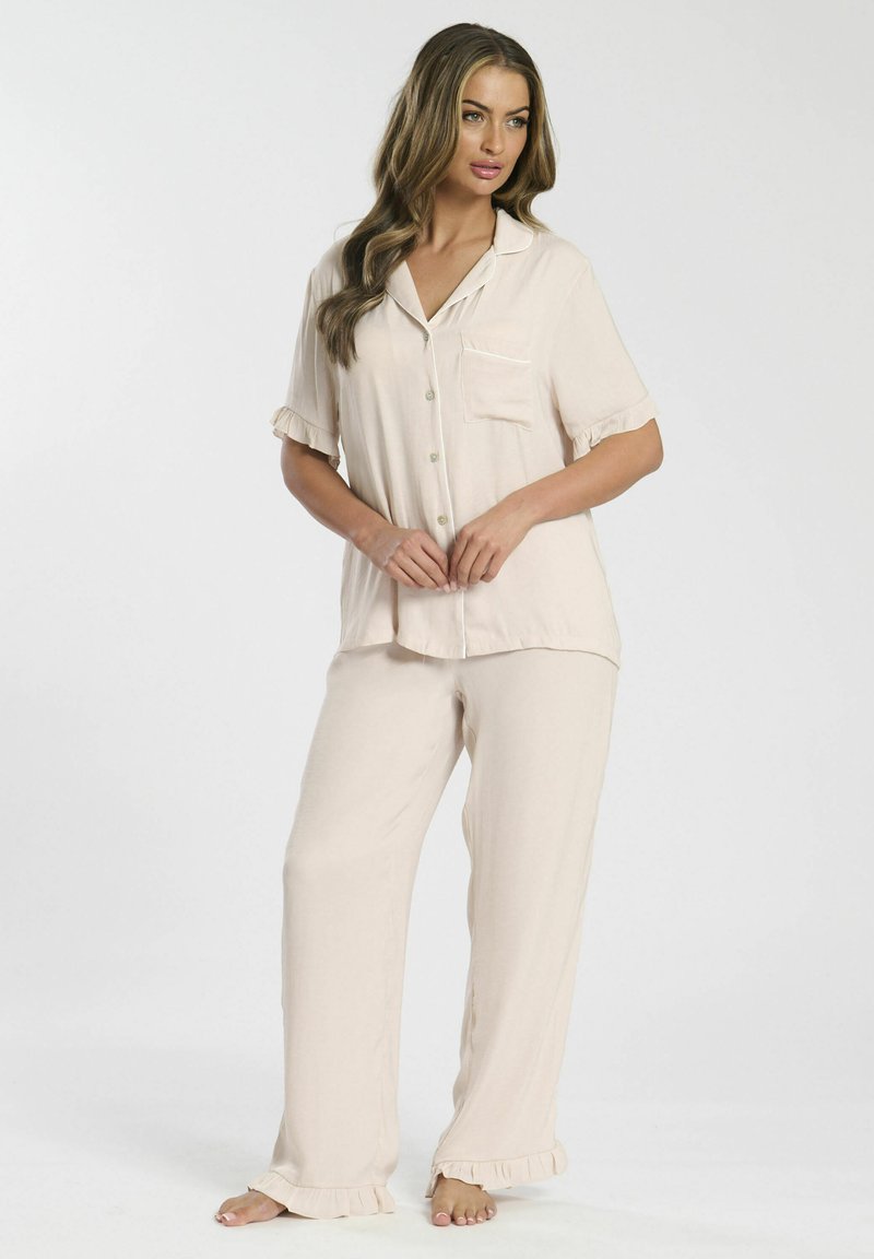 Pyjamabroekset in een zachte beige stof met een short-sleeve button-up top met een borstzak en een gerimpelde zoom, gecombineerd met losse broek.