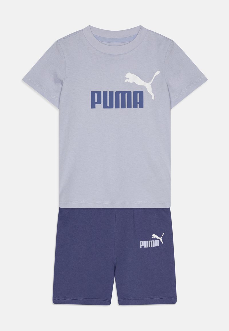 Tricou scurt cu mâneci, de culoare gri deschis, având un logo „PUMA” de culoare albastră închisă și o grafică albă a unui puma, asociat cu pantaloni scurți de culoare albastră închisă cu un logo alb.