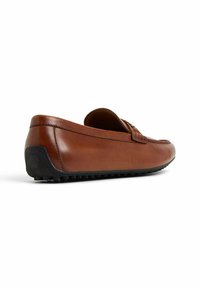 Mocasines de cuero marrón con puntera redondeada, acentos texturizados en la parte delantera y una suela de goma negra con patrones de tracción.