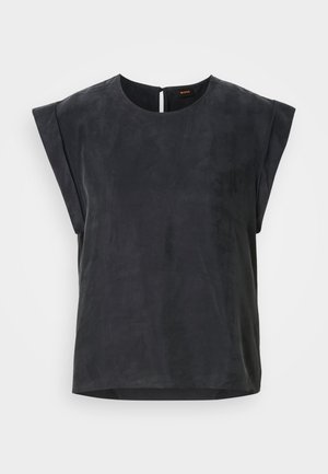 Svart kortermet topp med rund halslinning og minimalistisk design. Glatt tekstur med en subtil glans, med en nøkkelhullslukking bak.