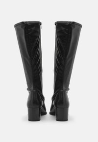Bottes en cuir noir hauteur genou avec une texture lisse, dotées d'un talon large et d'une fermeture éclair à l'arrière pour un enfilage facile.