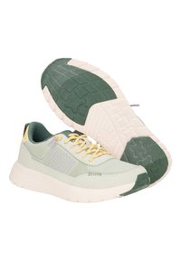 Hellgrüne Sportschuhe aus strukturiertem Stoff, mit gelben Schnürsenkeln und einer dunkelgrünen Gummisohle mit Wellenmuster.