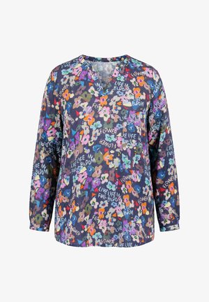 Blouse manches longues bleu marine avec imprimé floral coloré et texte blanc indiquant "Flower" et "Vis la vie en pleine floraison."