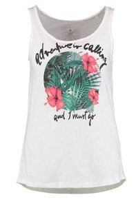 Witte tanktop van zachte stof, met een ronde tropische graphic van groene bladeren en roze bloemen, en zwarte tekstoverlays.