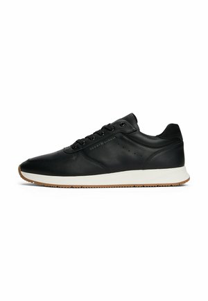 Zwarte leren sneakers met een witte tussenzool en een gumrubberen buitenzool. Voorzien van zes veterogen, geperforeerde accenten en een gebosseld logo op de zijkant.