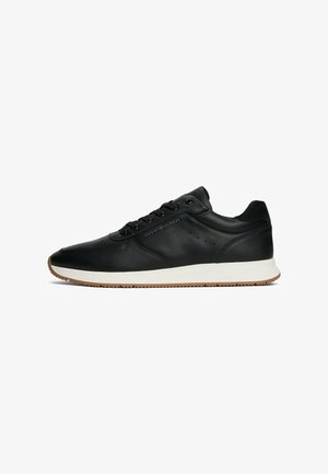 Schwarze Leder-Sneaker mit einer weißen Zwischensohle und einer Sohle aus Gummi. Verfügt über sechs Ösen, durchbrochene Akzente und ein geprägtes Logo an der Seite.