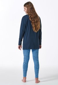 Long-sleeve navy top paired with patterned blue leggings featuring a floral design; soft fabric with a relaxed fit.