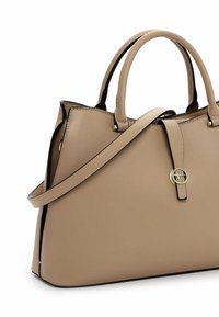 Beige Lederhandtasche mit zwei Henkeln, einem abnehmbaren Schulterriemen und einem goldfarbenen, runden Schnallendetail auf der vorderen Klappe.