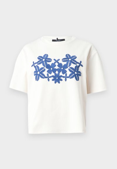 Λευκό T-shirt με κοντά μανίκια και στρογγυλή λαιμόκοψη, με κεντρικό μπλε κεντητό λουλουδάτο σχέδιο στο ύψος του στήθους.