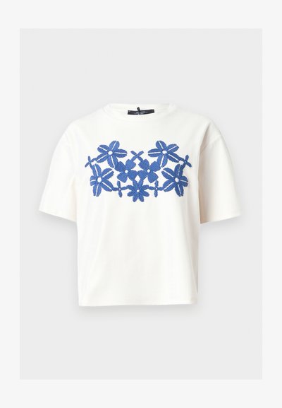 Λευκό T-shirt με κοντά μανίκια και στρογγυλή λαιμόκοψη, με κεντρικό μπλε κεντητό λουλουδάτο σχέδιο στο ύψος του στήθους.