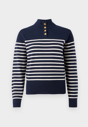 Sötétkék pulóver vízszintes fehér csíkokkal, magas gallérral és három arany gombbal ellátott gombolással a nyaknál.