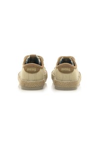 Zapatillas de lona beige con un tacón de ante marrón texturizado, suela de goma y detalles de tejido ligero. Presenta el logo de la marca en el tacón.