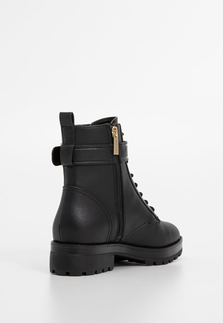 Schwarze Leder-Ankle-Boots mit strukturiertem Obermaterial, seitlichem Reißverschluss und Schnürung auf der Vorderseite. Dicke Sohle mit einer robusten Profilierung.