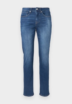 Denimjeans i medium blå vask, rett ben design, med fem lommer, frontknapp-lukking og minimale whiskering-detaljer.