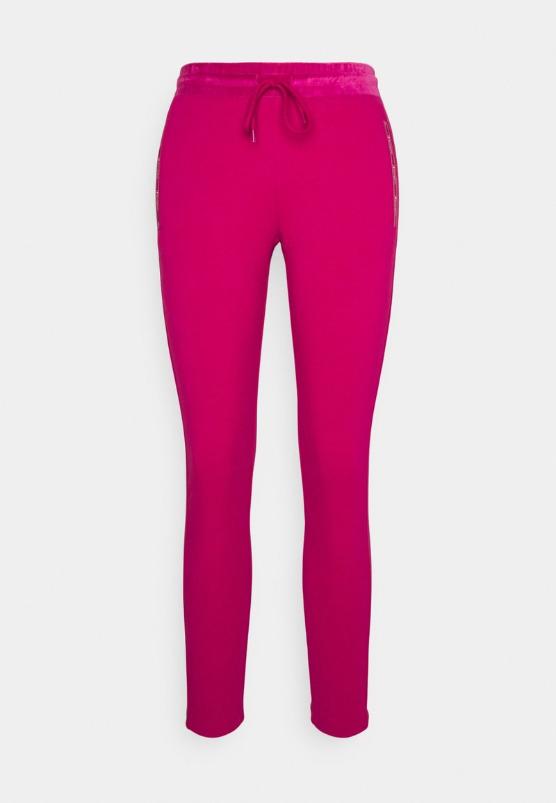 Strakke roze sweatpants met een trekkoord in de taille en subtiele zijdetails, weergegeven tegen een witte achtergrond.