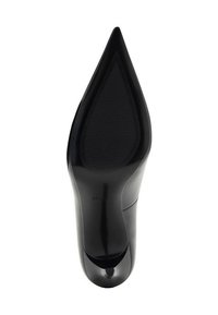 Zapato de tacón alto negro con punta afilada, acabado de charol suave y suela de goma texturizada. Presenta un corte en la zona de los dedos.