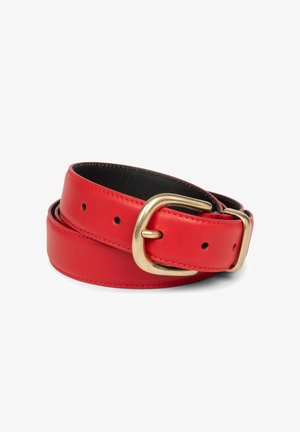 Ceinture en cuir rouge roulée avec une boucle en métal doré arrondie et plusieurs trous d'ajustement sur un fond blanc.