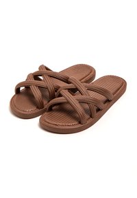 Sandalias deslizantes trenzadas de color marrón con un diseño de tiras entrecruzadas, suela plana y superficie texturizada para agarre y comodidad. Material ligero.