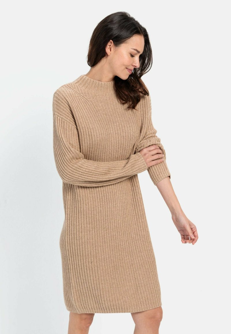 Strickkleid aus weichem Beige, mit geripptem Muster, Rundhalsausschnitt und langen Ärmeln mit leicht umgeschlagenen Bündchen.
