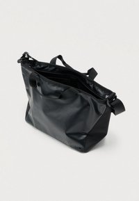 Μαύρη τσάντα tote από ανθεκτικό, λείο υλικό. Διαθέτει ρυθμιζόμενους ιμάντες, κλείσιμο με φερμουάρ και διακριτικό λογότυπο στη μία πλευρά.