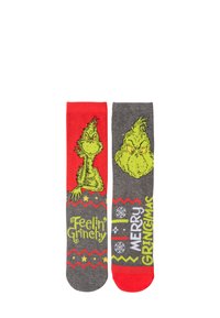 Calze grigie con dettagli rossi caratterizzate da un design del Grinch, testo "Mi sento Grinchoso" e "BUON GRINCHMAS", con motivi a zigzag e fiocchi di neve.