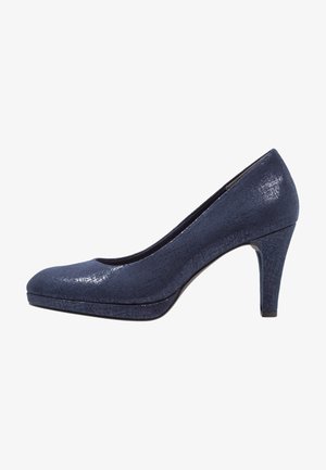 Zapato de tacón alto azul marino con punta redondeada, superficie texturizada y tacón de altura media. Acabados lisos en la punta y una plataforma sólida.