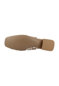 Zapato plano con parte superior trenzada en tonos beige y marrón. La suela de goma resistente presenta un patrón geométrico. Diseño de parte trasera abierta para facilitar el uso.
