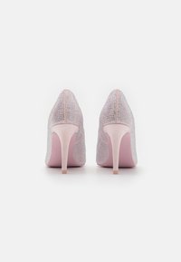 Chaussures à talons hauts en maille rose clair avec des embellissements en strass. Design à bout pointu et talon aiguille élégant. Texture douce.