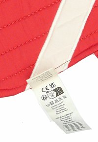 Rode gewatteerde stof met diagonale stiksels en een crèmekleurige streep. Bevestigd waslabel met wasinstructies en stofdetails.