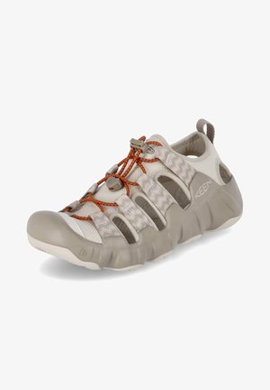 Lightweight, flexible water shoes in cream and gray, with a mesh upper, rubber sole, dynamic lacing system, and padded collar for comfort.