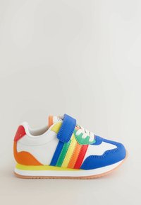 Lasten lenkkarit, joissa on sinisiä, vihreitä, keltaisia, oransseja ja punaisia paneeleja, valkoiset nauhat ja sininen tarranauha vaalealla taustalla.