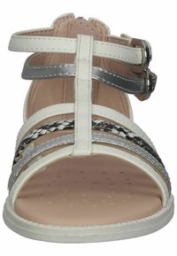 Sandali strappy bianchi e argento realizzati in materiale simile alla pelle, con dettagli intrecciati in bianco e nero e una soletta imbottita rosa.