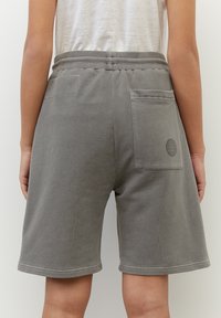 Shorts en coton gris à coupe décontractée, dotés de deux poches arrière et d'une ceinture douce. Le tissu présente une texture lisse et un design décontracté.