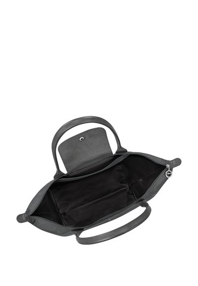 Black open handbag with two handles, zippered main compartment, and flap with snap button closure, showing empty interior lining.