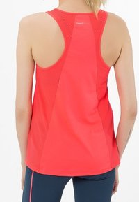 Camiseta deportiva de color rosa brillante con un diseño de espalda racing, paneles de malla y una textura de tela suave. Logotipo visible en la parte superior de la espalda.