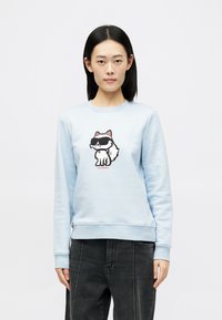Sweatshirt azul claro em tecido macio, com uma impress�ão de um gato de cartoon a usar óculos de sol na parte da frente. Punhos e barra canelados. Corte casual.