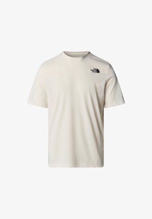 Camiseta de manga corta beige hecha de algodón, con un cuello redondo y un pequeño logo negro en la parte superior izquierda del pecho. Textura suave.