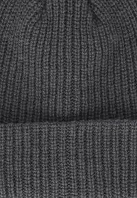 Donkergrijze gebreide beanie met een geribbeld ontwerp en een opgerolde rand. Gemaakt van zachte wol, heeft het een textuur met zichtbare stiksels.