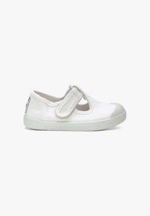 Chaussure enfant en toile blanche avec bride auto-agrippante et semelle en caoutchouc, vue de côté sur fond blanc.