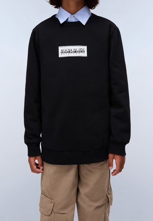 Zwarte sweatshirt met een ronde hals, voorzien van een wit logo op de borst. Ribgebreide manchetten en zoom, gecombineerd met beige cargobroek.