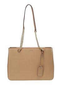 Sac fourre-tout DKNY tan avec une finition en faux cuir lisse, des poignées à chaînes doubles et une sangle, et une étiquette décorative attachée.