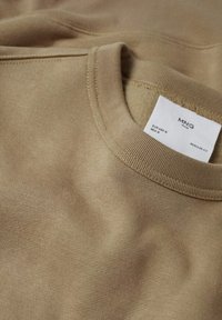 Felpa beige con girocollo, cuciture visibili e etichetta bianca con la scritta "MNG Man", taglia M, vestibilità regolare.